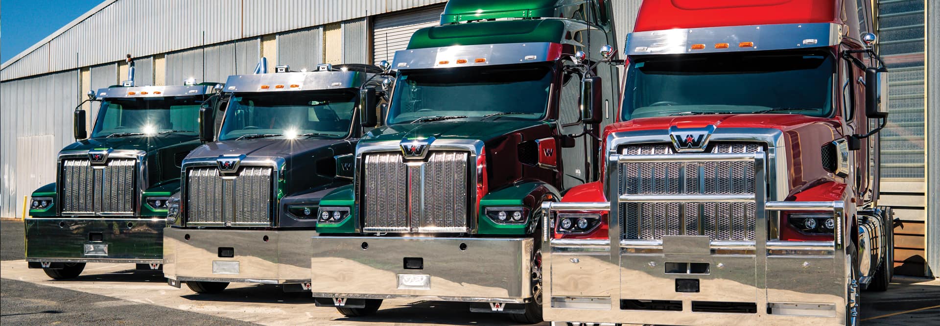 four stationery western star trucks in a line